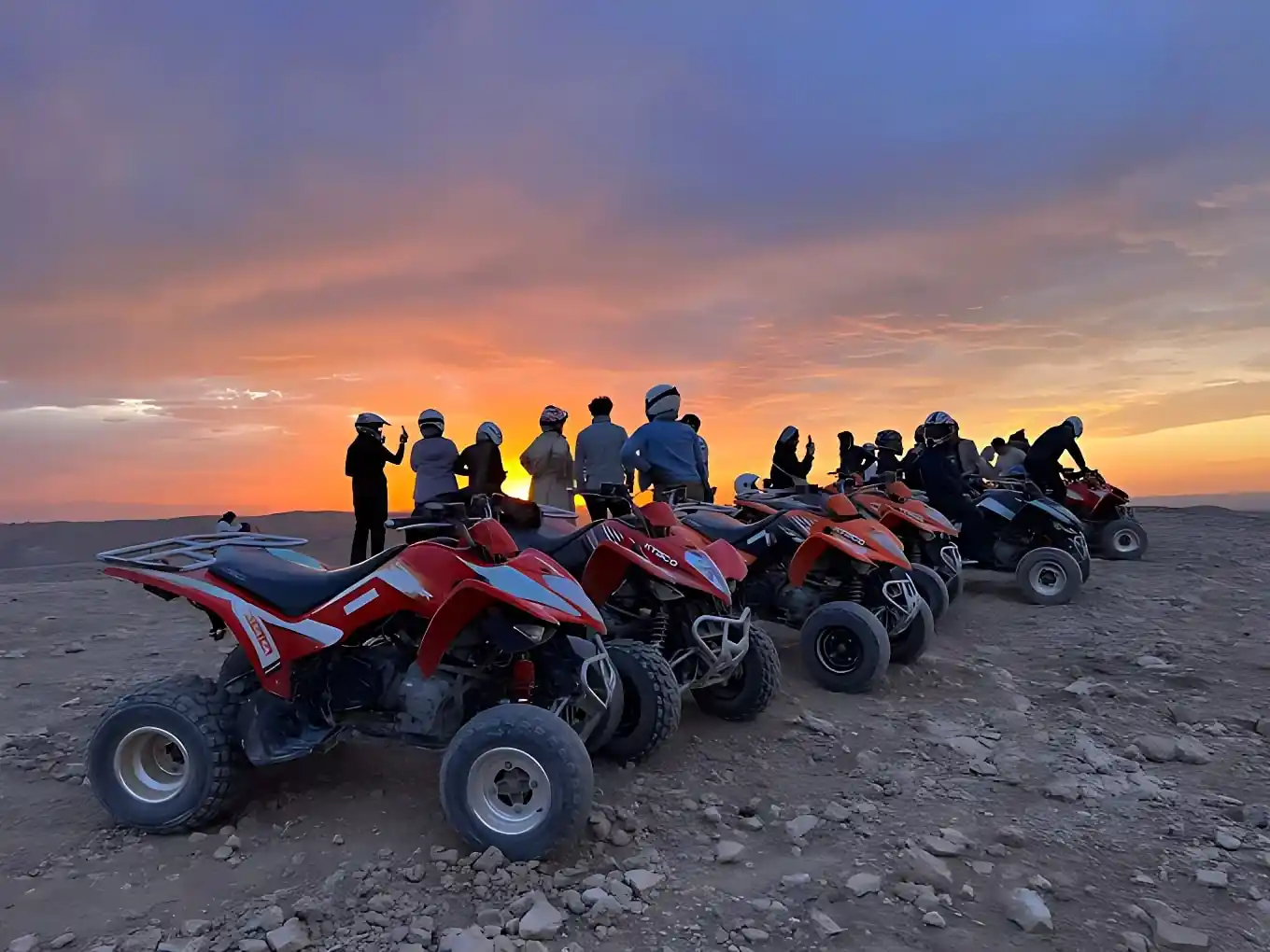 Quad de face, piste ocre, ciel immense bleu cobalt