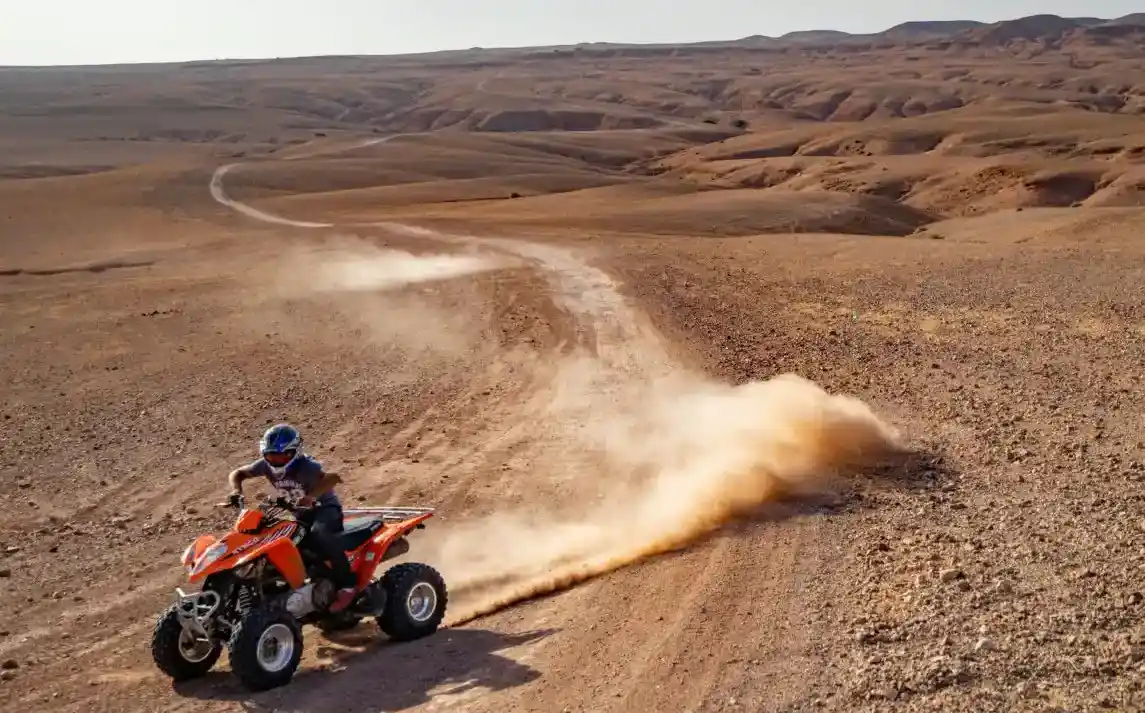 Nuage de poussière rouge derrière un quad à pleine vitesse